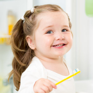 Toddler girl patient smiling with toothbrush